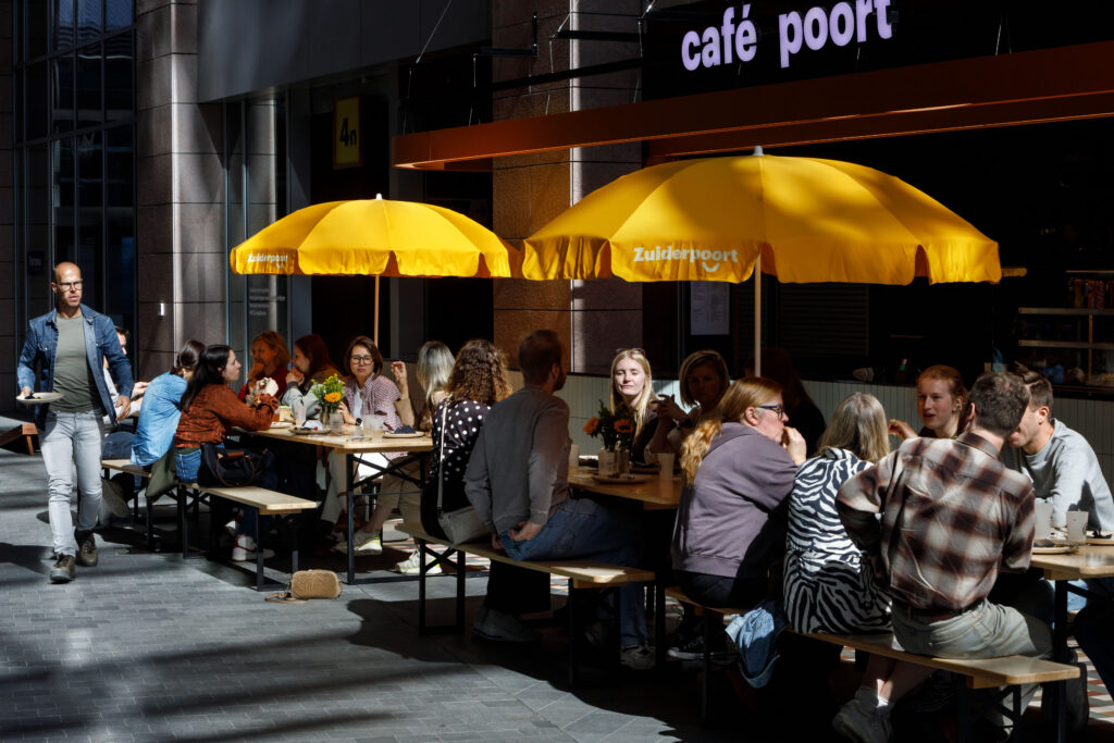 Colleagues lunching under yellow parasols at the Zuiderpoort Playground