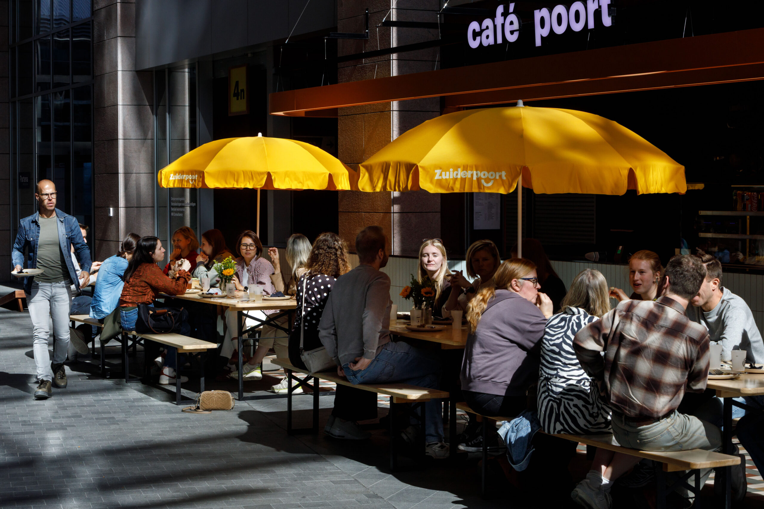 Colleagues lunching under yellow parasols at the Zuiderpoort Playground